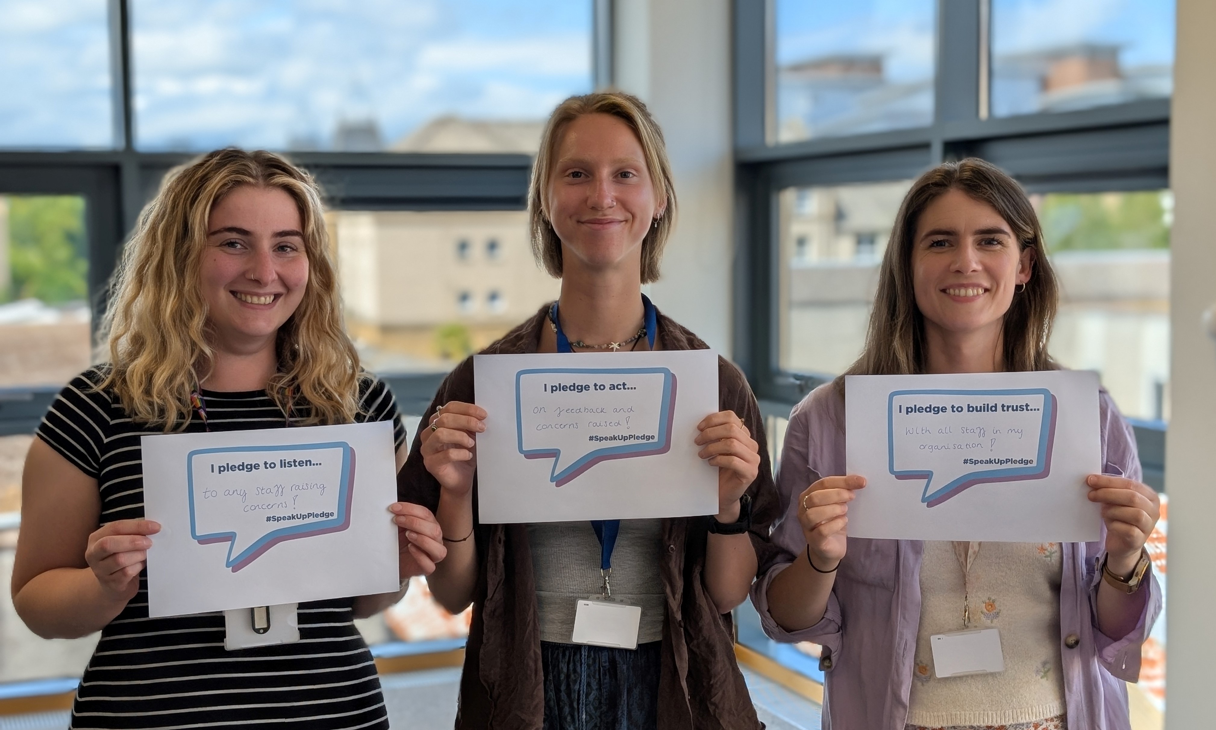 Three people holding pledges